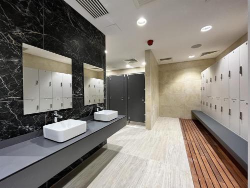 a bathroom with two sinks and black marble walls at NEW Luxury Sunrise Oceanview Aparthotel in Gibraltar in Gibraltar