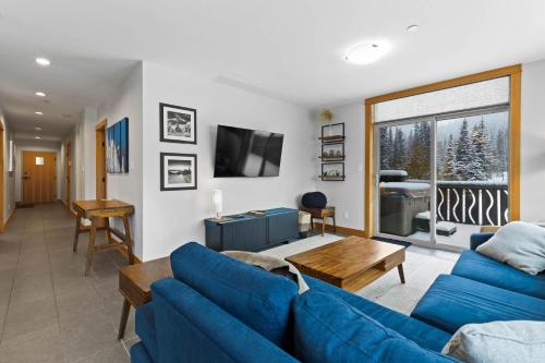 Kookaburra Lodge #203 By Bear Country في صن بيكس: غرفة معيشة مع أرائك زرقاء وتلفزيون