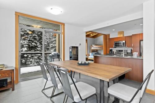 een keuken en eetkamer met een houten tafel en stoelen bij Kookaburra Lodge #203 By Bear Country in Sun Peaks