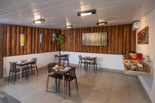 een restaurant met houten muren en tafels en stoelen bij Pousada Vento Sul in Chapada dos Guimarães