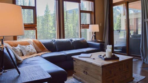 a living room with a blue couch and a table at Stones Throw #24 in Sun Peaks