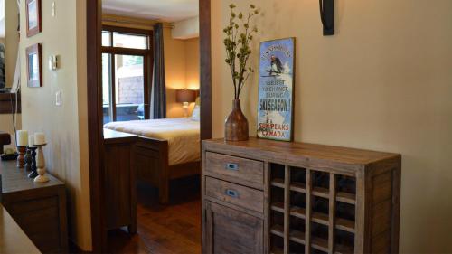 a bedroom with a bed and a dresser with a mirror at Stones Throw #24 in Sun Peaks