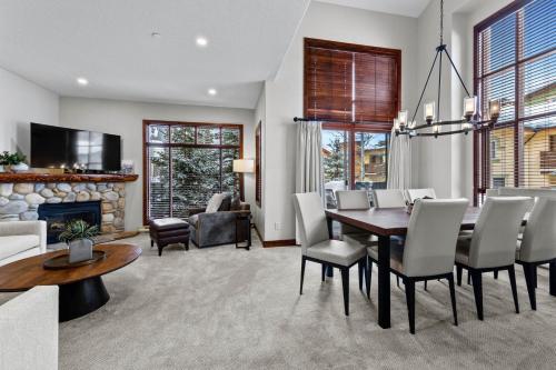a dining room with a table and chairs and a fireplace at Trappers Landing #05 By Bear Country in Sun Peaks
