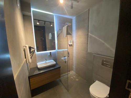 a bathroom with a toilet and a sink and a mirror at Warszawski Alaçatı in Alaçatı
