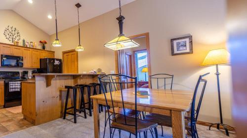 a kitchen and dining room with a wooden table and chairs at Crystal Forest #54 By Bear Country in Sun Peaks