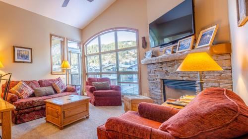 a living room with a couch and a fireplace at Crystal Forest #54 By Bear Country in Sun Peaks