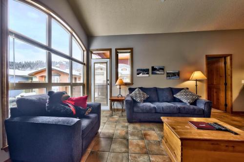 a living room with two blue couches and a table at Crystal Forest #72 By Bear Country in Sun Peaks