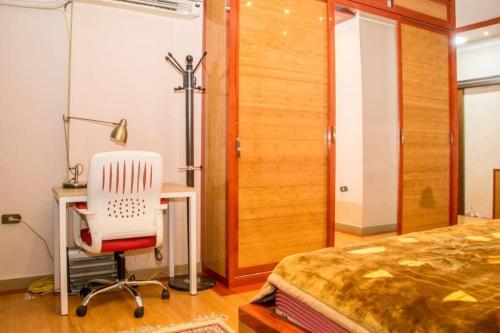 1 dormitorio con cama, escritorio y silla en LuxuryApartmentDirectToTheNile en El Cairo