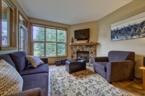 a living room with two couches and a fireplace at Crystal Forest #65 By Bear Country in Sun Peaks