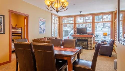 a living room with a dining room table and a fireplace at Settlers Crossing #61 by Bear Country in Sun Peaks