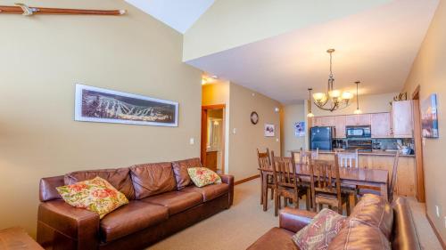 a living room and kitchen with a couch and a table at Settlers Crossing #11 by Bear Country in Sun Peaks