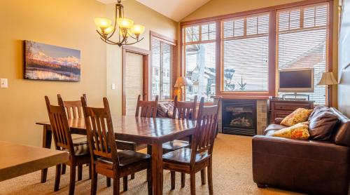 a dining room with a table and chairs and a couch at Settlers Crossing #11 by Bear Country in Sun Peaks