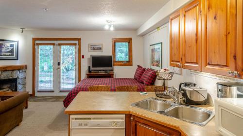 a kitchen with a living room with a couch at Timberline Village #45 By Bear Country in Sun Peaks