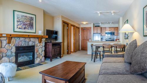 a living room with a couch and a fireplace at Fireside Lodge #413 By Bear Country in Sun Peaks