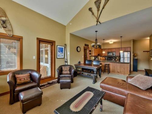 a living room with leather furniture and a kitchen at Settlers Crossing #70 by Bear Country in Sun Peaks