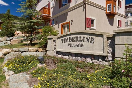 a building with a sign in front of a yard at Timberline Village #14 By Bear Country in Sun Peaks