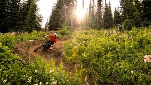 a man riding a dirt bike on a dirt trail at Timberline Village #14 By Bear Country in Sun Peaks