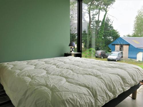 ein großes Bett in einem Schlafzimmer mit einem großen Fenster in der Unterkunft Maison Pleumeur-Bodou, 4 pièces, 6 personnes - FR-1-368-306 in Pleumeur-Bodou