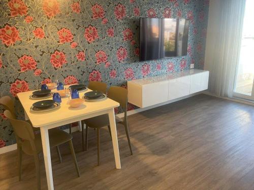 une salle à manger avec une table, des chaises et une télévision dans l'établissement SUMMER PARADISE, à Bari