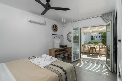 a bedroom with a bed and a dining room at Orama Suites Milos in Adamantas