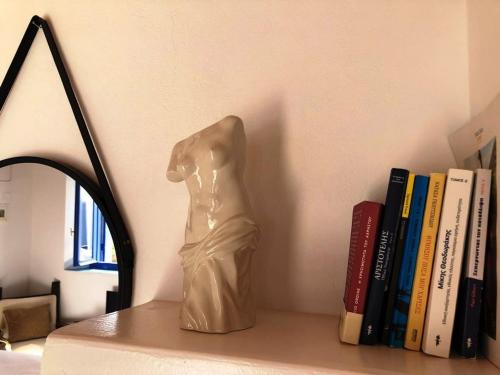 FiropótamosにあるThe Nestの本棚に腰掛けた女性像