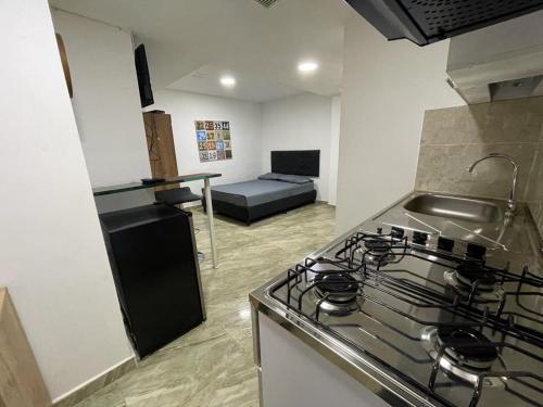 cocina con fogones y sofá en una habitación en Apartamento con aire acondicionado al lado de la Unidad Deportiva de Belén y a 10 minutos de Plaza Mayor - 2, en Medellín