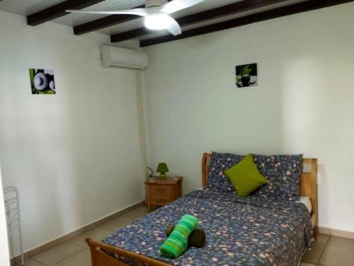 1 dormitorio con 1 cama con almohada verde en Appartement de 2 chambres avec vue sur la mer terrasse amenagee et wifi a Bouillante a 4 km de la plage, en Bouillante