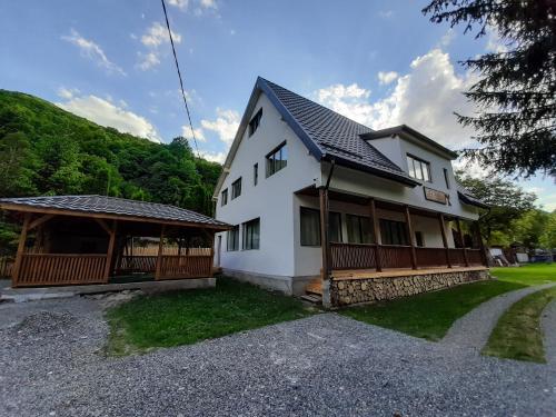 uma casa branca com um telhado preto em Casa Phoenix em Baisoara