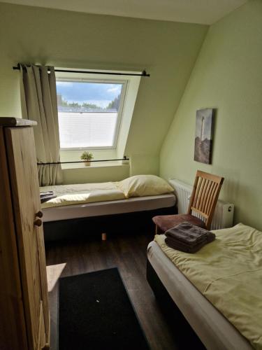 a small room with two beds and a window at Haus Regenpfeifer in Büsum
