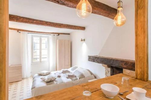 une chambre avec un lit et une table en bois dans l'établissement AUTHENTIQUE STUDIO au CŒUR du VILLAGE PROVENCAL, à Villeneuve-Loubet