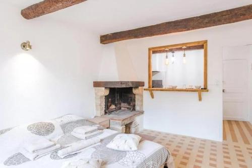 une chambre avec un lit et une cheminée dans l'établissement AUTHENTIQUE STUDIO au CŒUR du VILLAGE PROVENCAL, à Villeneuve-Loubet