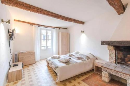 une chambre avec un lit et une cheminée dans l'établissement AUTHENTIQUE STUDIO au CŒUR du VILLAGE PROVENCAL, à Villeneuve-Loubet