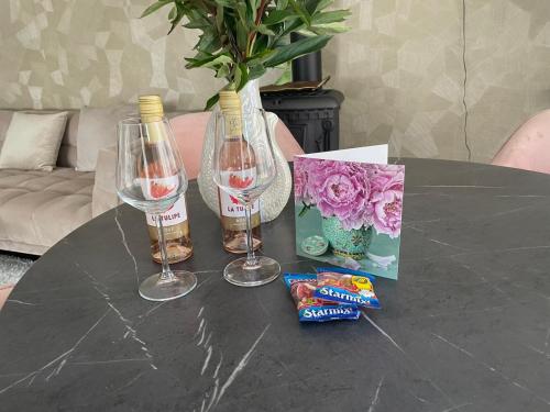 a table with two wine glasses and snacks on it at Charmant, ontspannen Molenzicht in Ootmarsum