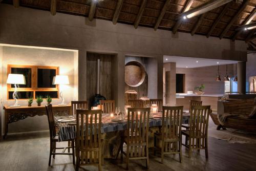 a dining room with a long table and chairs at Lush Private Game Lodge in Pilanesberg