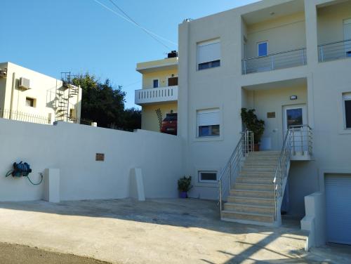 una casa blanca con escaleras y una valla en Serenity apartment Mochlos, en Mókhlos