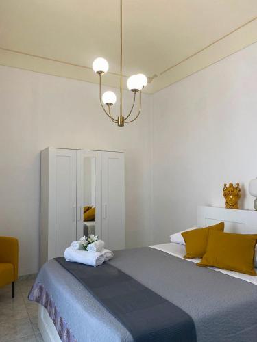a bedroom with a large bed and a chandelier at Casa Noto in Noto