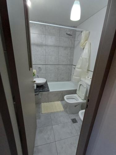 a bathroom with a toilet and a tub and a sink at Departamento Torre Murguía in San Salvador de Jujuy