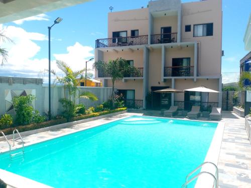 a villa with a swimming pool in front of a building at SOA LIA HOTEL in Miandrivazo