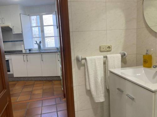 a bathroom with a sink and a shower with towels at HyP- A Casa do Correo - O Balcón in Pontevedra