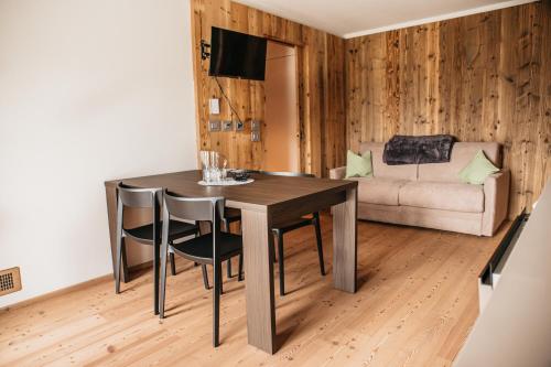 a dining room table with chairs and a couch at Exzelent Residence in Anterselva di Mezzo