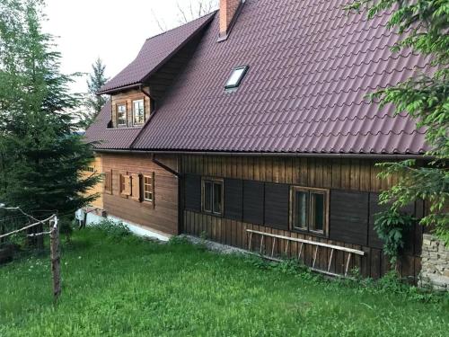 ein Holzhaus mit braunem Dach in der Unterkunft Chata filozofa in Skawica
