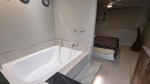 Habitación con baño con bañera blanca grande. en Hotel Platino Termas All Inclusive en Termas de Río Hondo
