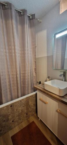 baño con lavabo y cortina de ducha en Appartement 3 pièces avec jardin, en Valdeblore