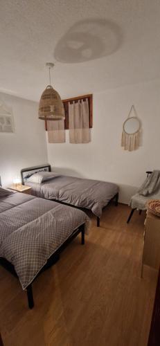 1 dormitorio con 2 camas y techo en Appartement 3 pièces avec jardin en Valdeblore