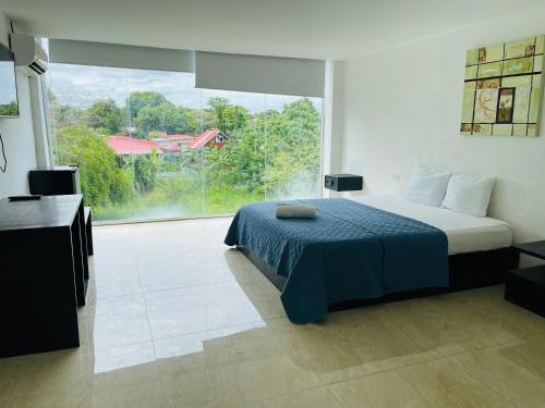 a bedroom with a bed and a large window at Gorgona Beach House in Nueva Gorgona