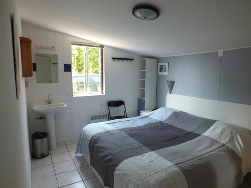 a bedroom with a bed and a sink and a window at Village Le Chat 3 Écuras in Écuras