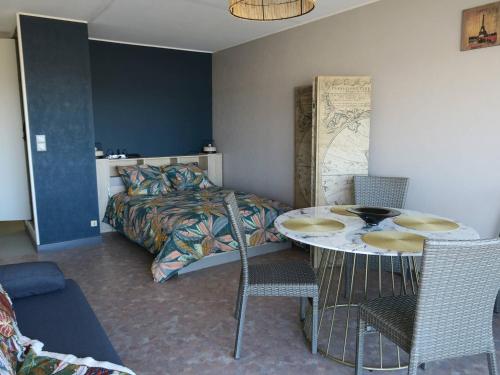 une chambre avec un lit, une table et des chaises dans l'établissement Appartement au port avec loggia et vue mer - Perros-Guirec - FR-1-368-336, à Perros-Guirec