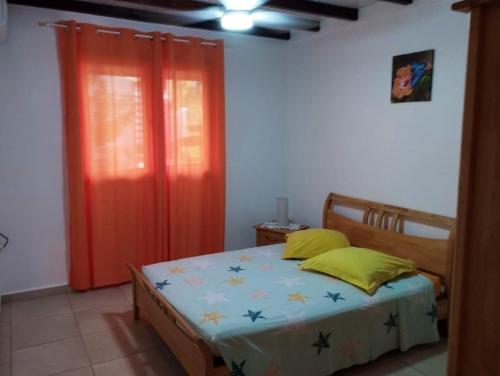 a bedroom with a bed and a red curtain at Appartement de 2 chambres avec vue sur la mer terrasse amenagee et wifi a Bouillante a 4 km de la plage in Bouillante