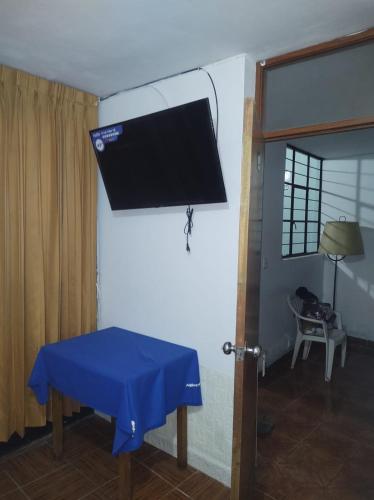 a room with a blue table and a tv on the wall at CasaBlanca in Nazca