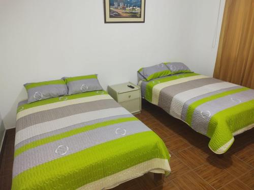 dwa łóżka siedzące obok siebie w pokoju w obiekcie CasaBlanca w mieście Nazca